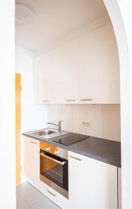 a kitchen with white cabinets and a sink at Fewo Schneckenhalde App 18 in Bad Säckingen +5 photos