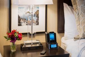 ケネバンクにあるPort Inn & Suites Kennebunk, an Ascend Collection Hotelのホテルルーム ベッドの横のテーブルに時計付