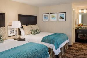 ケネバンクにあるPort Inn & Suites Kennebunk, an Ascend Collection Hotelのベッド2台と暖炉のあるホテルの部屋