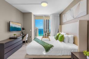 a bedroom with a bed and a desk and a window at Luxury 2BR Apt With Ocean View Pool & Amenities in Hollywood Beach +64 photos