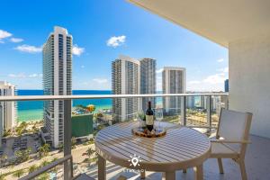 a table and chairs on a balcony with a view of the ocean at Luxury 2BR Apt With Ocean View Pool & Amenities in Hollywood Beach