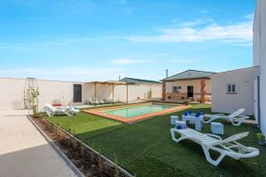 a backyard with a swimming pool and lounge chairs at Casa Rural Lola - Lantejuela in La Lantejuela