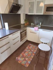 cocina con armarios blancos, mesa y taburete en Signature Living, en Burghaun