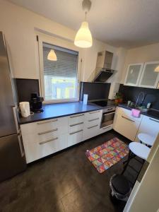 Una cocina con gabinetes blancos y una encimera azul. en Signature Living, en Burghaun