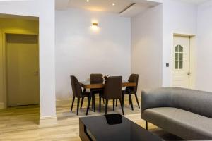 a living room with a table and chairs and a couch at Zilla Luxury - Lifecamp in Abuja