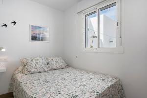 a bedroom with a bed and a window at Atico Juani in Conil de la Frontera