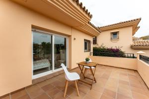 eine Terrasse mit einem Tisch und einem weißen Stuhl in der Unterkunft Villa in Los Flamencos in Sitio de Calahonda