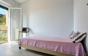 a bedroom with a bed and a chair and a window at Nice Apartment In Zoagli With Wifi in SantʼAmbrogio