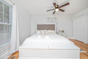 a white bedroom with a bed and a ceiling fan at The Terry Sanford Guest House Apt A in Fayetteville