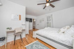 a bedroom with a bed and a desk and a ceiling fan at The Terry Sanford Guest House Apt A in Fayetteville