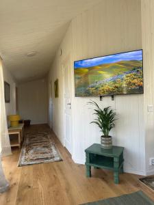 a living room with a painting hanging on the wall at Holiday home Kolmårdsgården in Kolmården