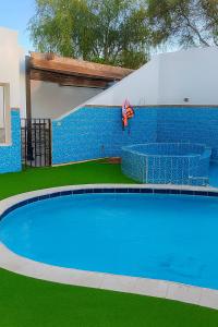 ジッダにあるفيلا الاحلام aの家の前の青い大型スイミングプール