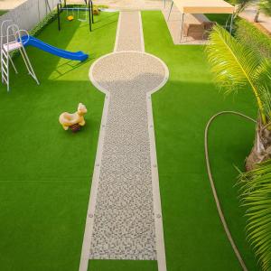 ジッダにあるفيلا الاحلام aの芝生の上に大きな「T」の文字がある庭