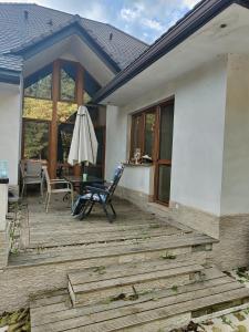 にあるAgroturystyka Kruszynaの椅子と傘が置かれたデッキ