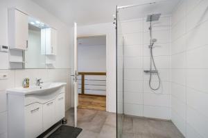 a white bathroom with a shower and a sink at City Villa Bad Dürrheim - Maisonette in Bad Dürrheim +24 photos