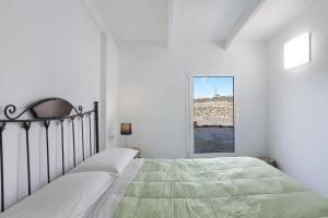a white bedroom with a bed and a window at Villa Luna Wifi Fibra in Lajares
