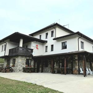 een groot wit gebouw met een veranda en stoelen bij Къща за гости МЕЧА СТЪПКА in Gela