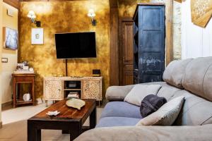 a living room with a couch and a tv at Casa Quimera in Gilgarcía