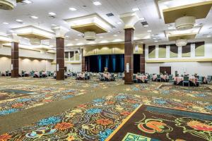 a banquet hall with tables and chairs and a large rug at Oasis Hotel and Conv Center, an Ascend Collection Hotel in Springfield +65 photos