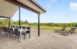 ein Esstisch und Stühle auf einer Terrasse in der Unterkunft Gorgeous Home In Ringkøbing With Sauna in Ringkøbing + 27 Fotos