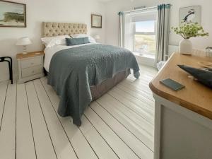 a bedroom with a bed and a desk and a window at Upper White Gates in Little Haven +14 photos