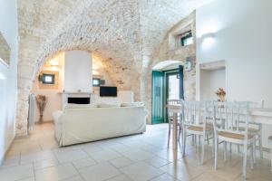 een woonkamer met een witte bank en een tafel bij Casa Maestra in Ceglie Messapica
