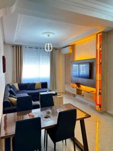 a living room with a blue couch and a table at Appartement Tanger Stade ibn batouta in Tangier