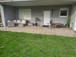 a patio with a couch and a table in front of a house at Ferienwohnung Oskar in Gschwend
