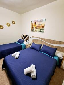 duas camas num quarto com lençóis azuis em Hostal Doña María em Valdemoro