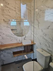 a bathroom with a toilet and a sink and a mirror at Cabana Sol Poente PR in São José dos Pinhais