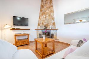 a living room with a fireplace and a tv at Can grau petit in Sencelles