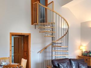 - un escalier en colimaçon dans le salon doté d'un canapé dans l'établissement Bwthyn Bwlch, à Denbigh