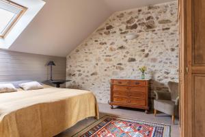 a bedroom with a bed and a stone wall at Le Theureau Gîte voor 6 personen in Millay +16 photos