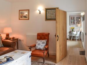 a living room with a chair and a door at Grattan Cottage in Bow