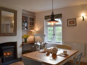 a dining room with a table and a fireplace at Grattan Cottage in Bow +11 photos