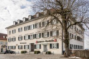 a white building with a tree in front of it at Ferienwohnung am Schloss in Heiligenberg