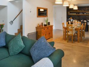 een woonkamer met een groene bank en een eetkamer bij The Haining in Elsdon