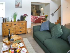 een woonkamer met een groene bank en een tafel bij The Haining in Elsdon