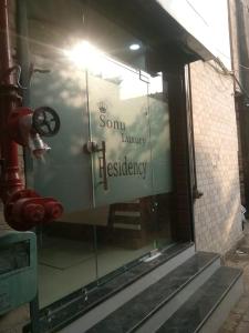 a window with a sign on the side of a building at Sonu luxury residency hotel in Amritsar