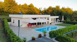 a house with a swimming pool and umbrellas at Dream House Banja Luka in Banja Luka