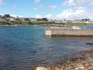 a body of water with a pier and buildings in the background at Home Farm - The Dairy -Uk34626 in Dunragit