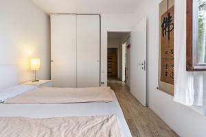 une chambre blanche avec un lit et un placard dans l'établissement Villa Verde, à Torri del Benaco