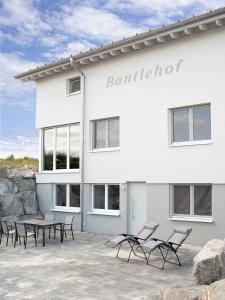 a building with chairs and a table in front of it at Bantlehof in Niedereschach