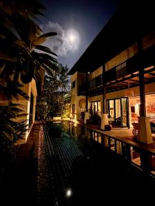 a building with a swimming pool at night at Phuket Hideaway Near Bang Tao in Laguna Phuket