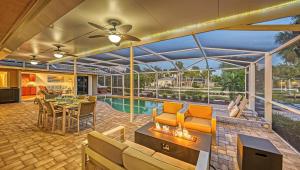 an indoor patio with a fireplace and a pool at Gulf Birdie - 5551 in Siesta Key