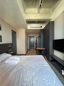 a bedroom with a large white bed and a tv at Tolive One - Ilha do Leite, Recife in Recife