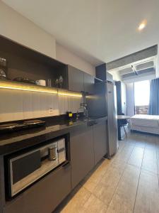 a kitchen with stainless steel appliances and a bedroom at Tolive One - Leite Island, Recife in Recife