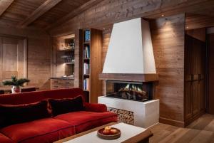 a living room with a red couch and a fireplace at Hotel Tyrol in Selva di Val Gardena