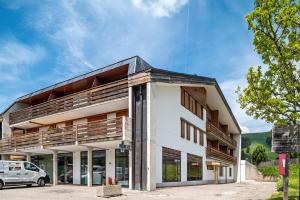 a white building with a black roof at Chalet Hubertus in Kastelruth