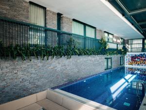 a swimming pool next to a brick building with plants at Lucky Monkey Hotel in Antalya